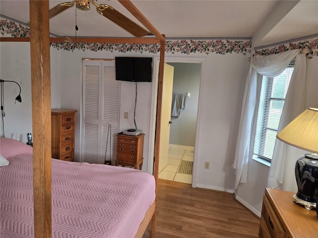 bedroom featuring multiple windows, hardwood / wood-style floors, a closet, and ensuite bathroom