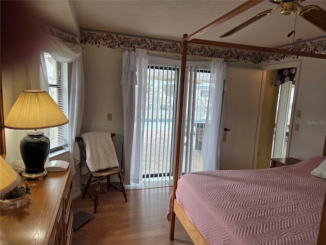 bedroom featuring ceiling fan, wood-type flooring, and a textured ceiling