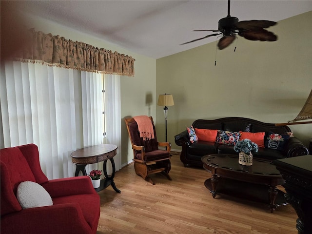 living area with lofted ceiling, ceiling fan, and light wood-style flooring