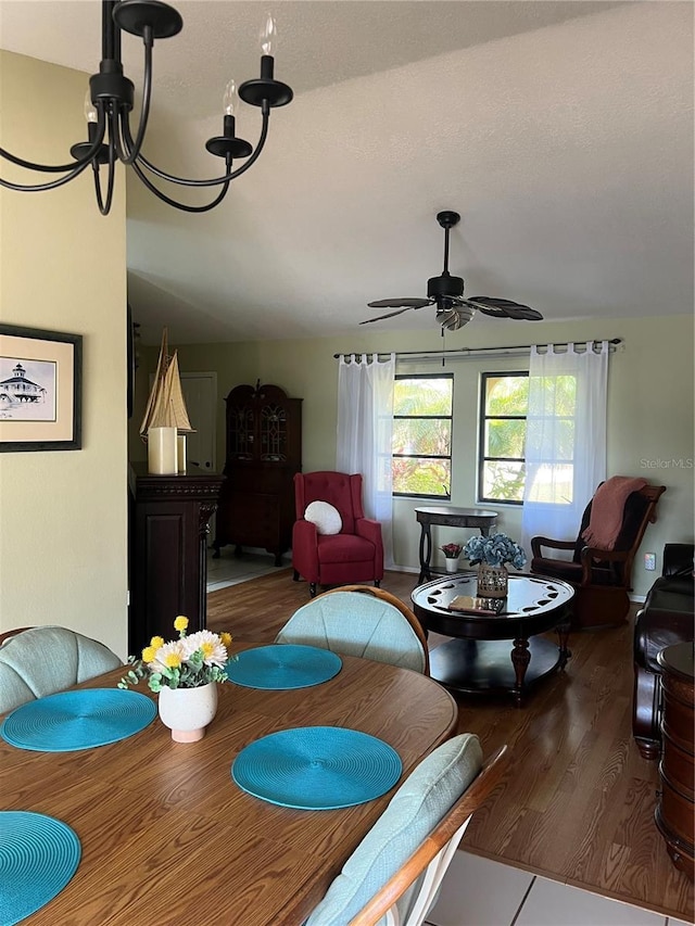 dining room featuring ceiling fan with notable chandelier and wood finished floors