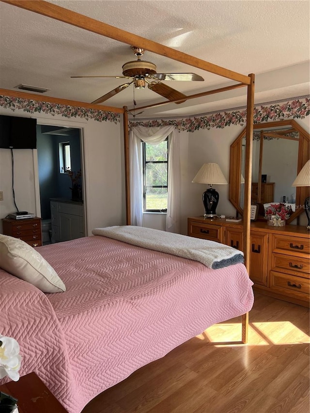 bedroom with visible vents, ceiling fan, a textured ceiling, and light wood finished floors