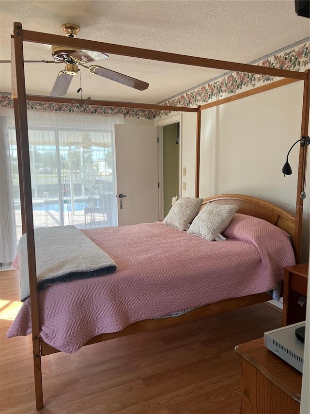 bedroom featuring a textured ceiling, a ceiling fan, and wood finished floors