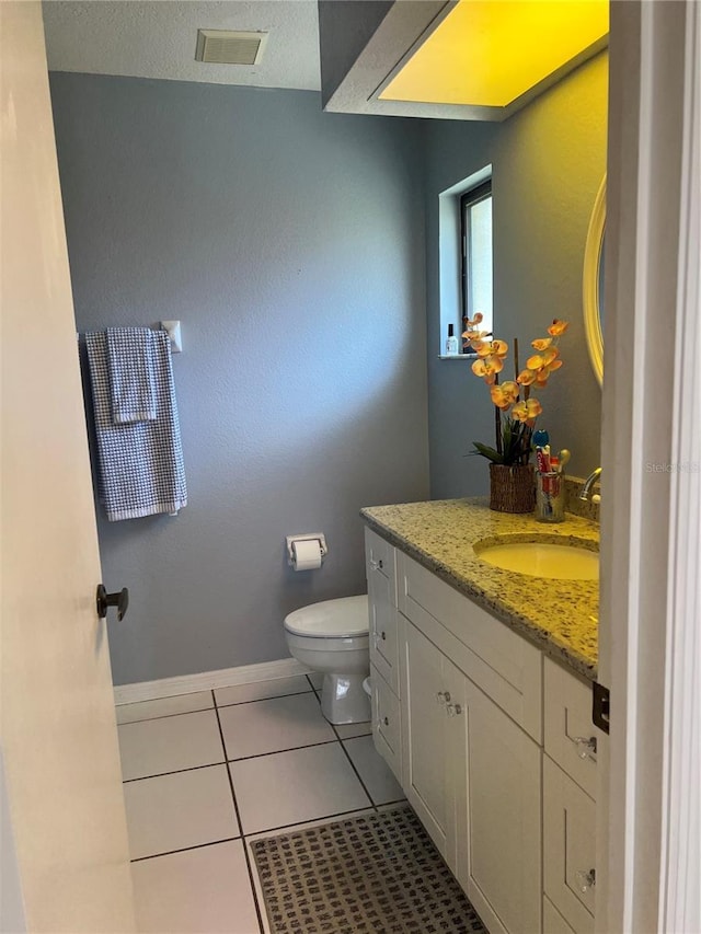 bathroom featuring tile patterned flooring, toilet, visible vents, vanity, and baseboards