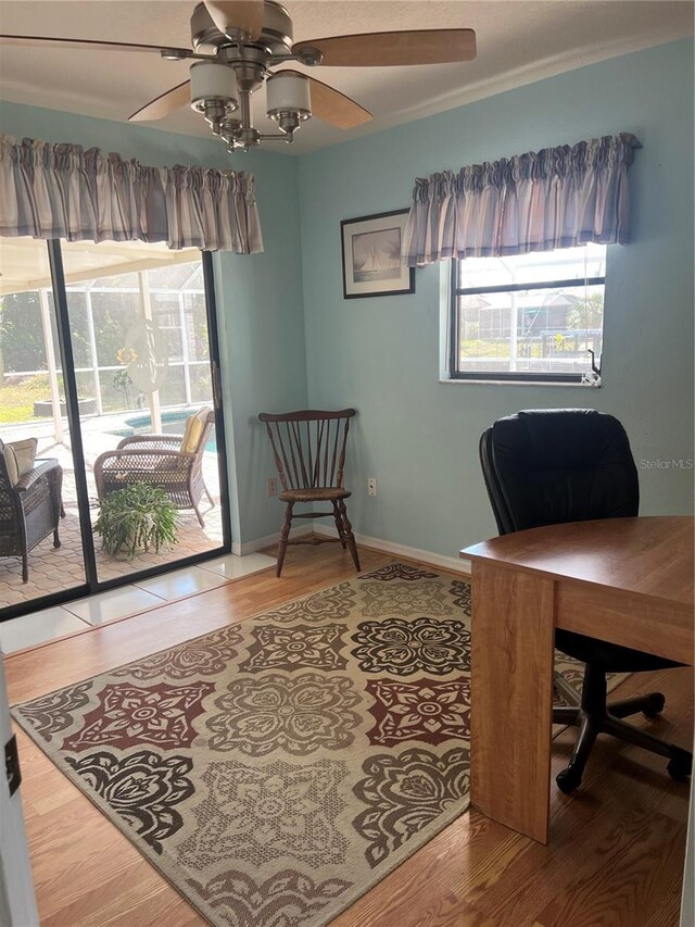 office area with ceiling fan, baseboards, and wood finished floors