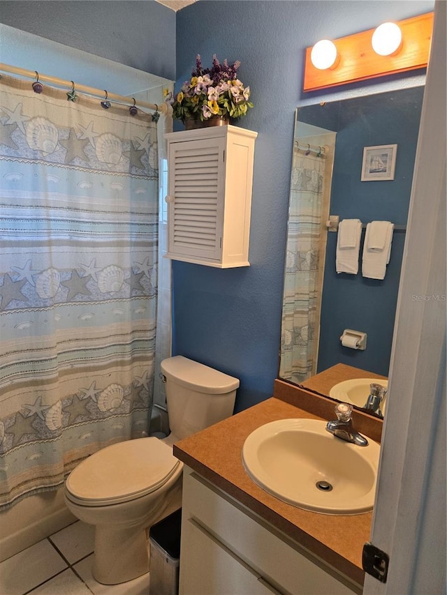 bathroom with tile patterned flooring, vanity, and toilet