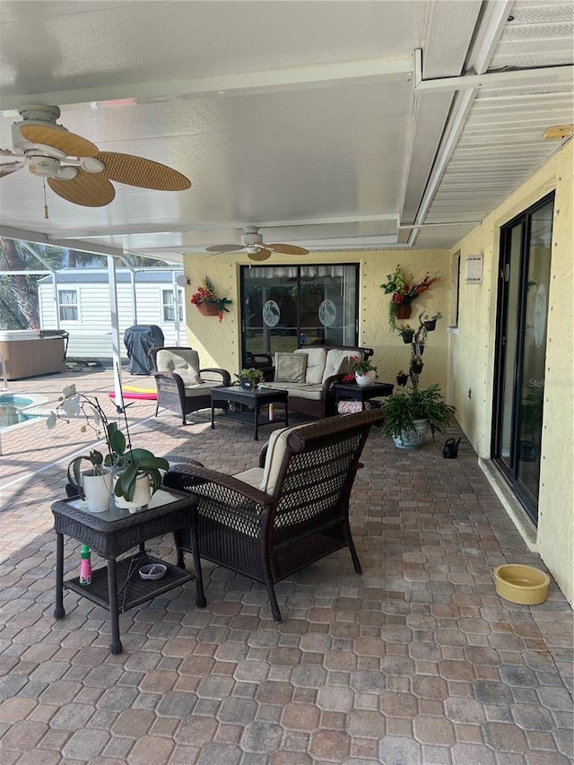 view of patio featuring outdoor lounge area, a ceiling fan, and a hot tub