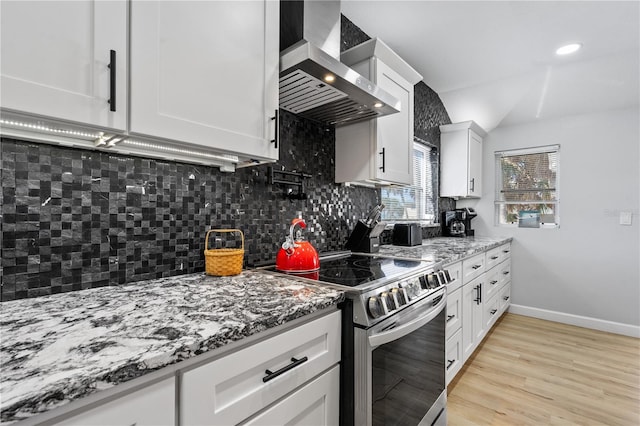 kitchen featuring white cabinetry, stainless steel electric range, light hardwood / wood-style floors, exhaust hood, and light stone counters