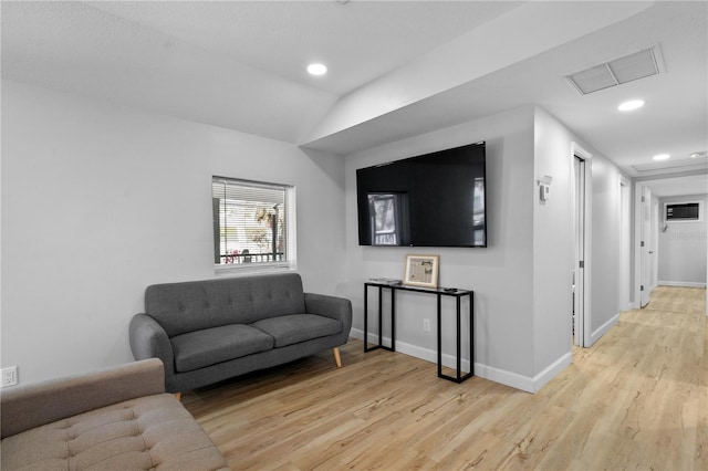 living room with light wood-type flooring and vaulted ceiling