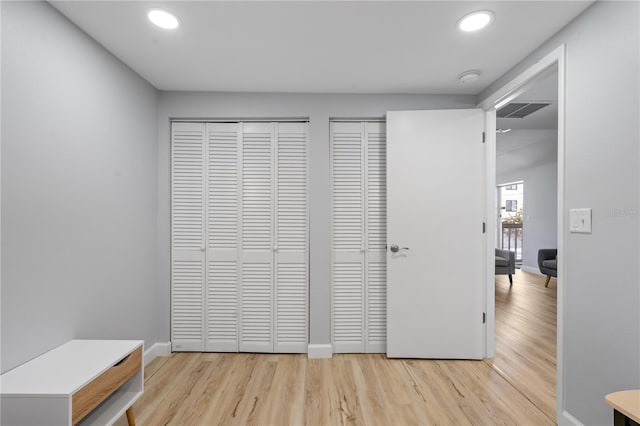 interior space featuring light hardwood / wood-style flooring and two closets