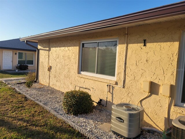 view of property exterior with central AC and stucco siding