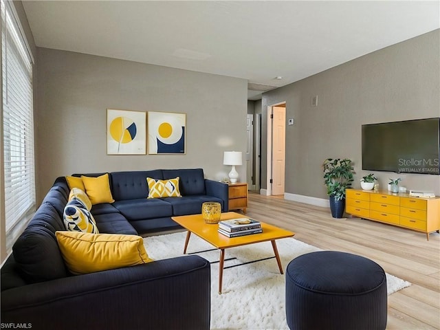 living area featuring light wood-type flooring and baseboards