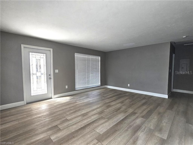 empty room with baseboards and wood finished floors