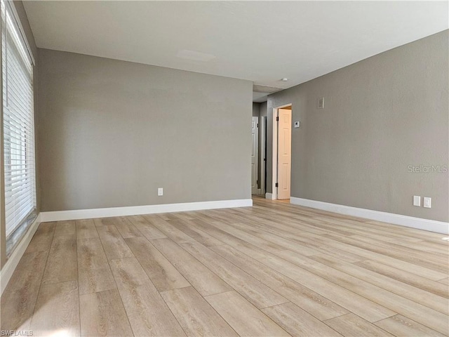 unfurnished room with light wood-style floors and baseboards