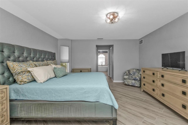 bedroom featuring light wood-type flooring, visible vents, and baseboards