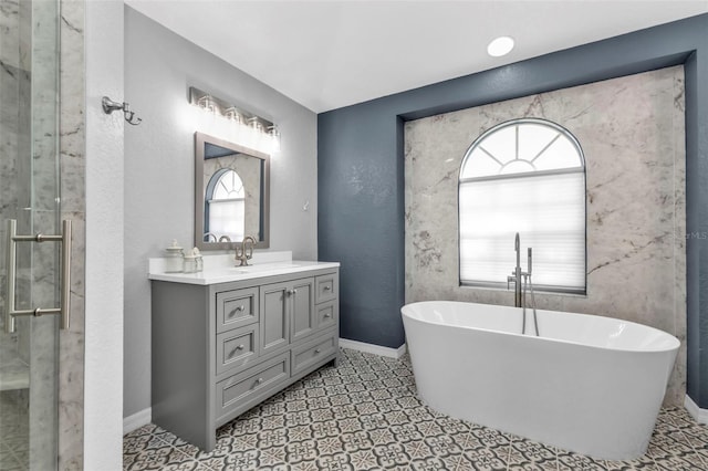 full bathroom with a soaking tub, a textured wall, a stall shower, vanity, and baseboards