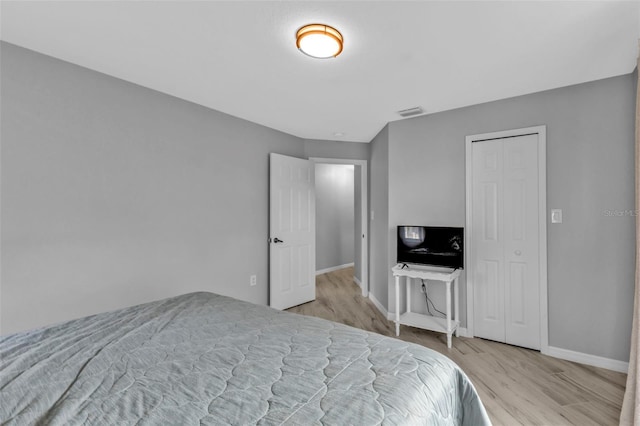 bedroom featuring light wood-type flooring, visible vents, and baseboards