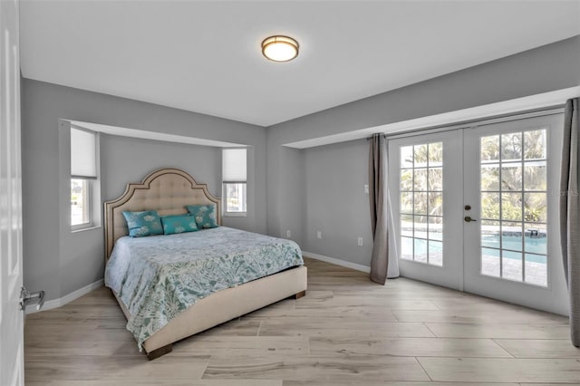 bedroom with baseboards, french doors, light wood finished floors, and access to exterior