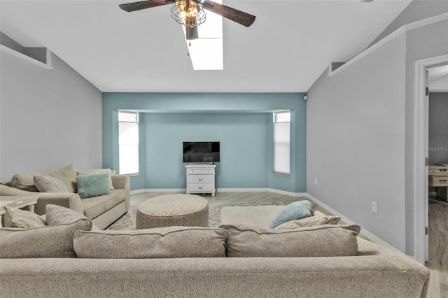 living area featuring lofted ceiling, wood finished floors, a ceiling fan, and baseboards