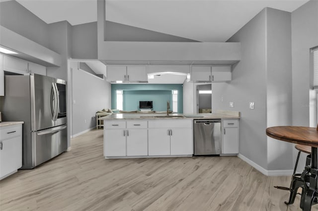 kitchen featuring stainless steel appliances, white cabinets, and light countertops