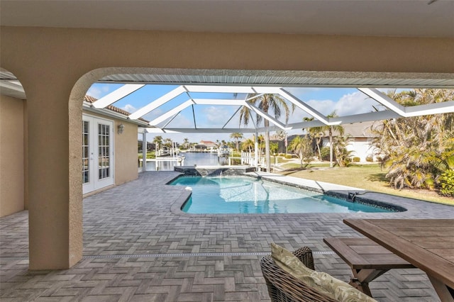 pool with glass enclosure, french doors, a patio area, and a water view