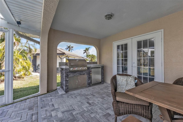 view of patio / terrace with exterior kitchen, french doors, and a grill