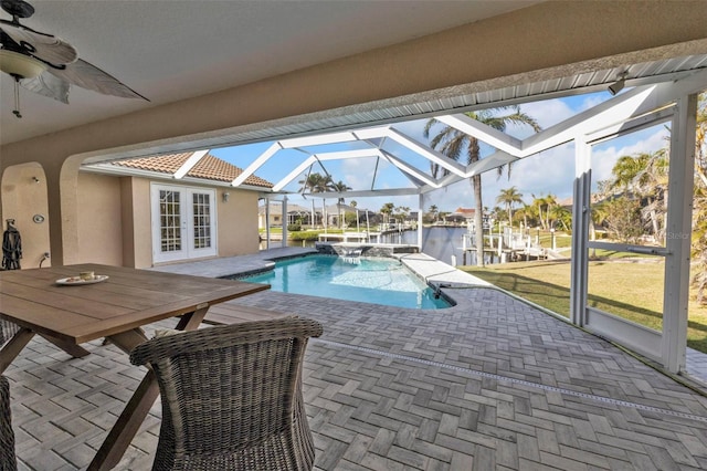 view of pool featuring a ceiling fan, a patio, a water view, a lanai, and french doors