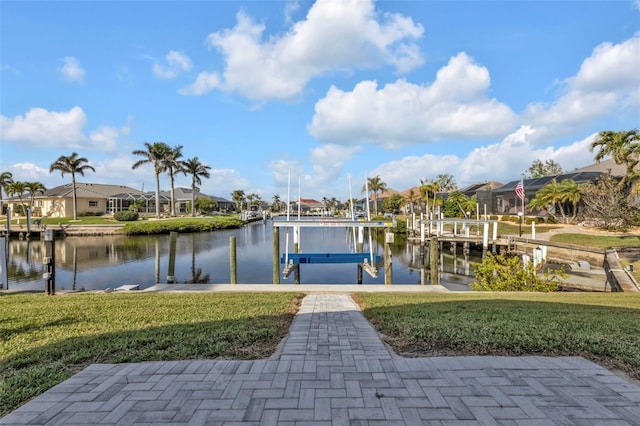 dock area with a water view, boat lift, and a residential view