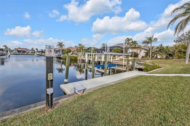 dock area featuring a water view, boat lift, a residential view, and a yard