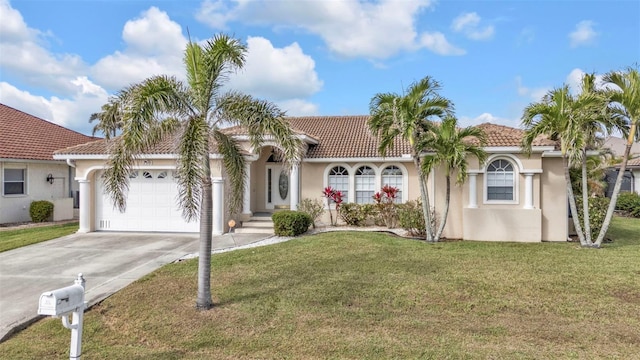 mediterranean / spanish house featuring stucco siding, concrete driveway, an attached garage, a front yard, and a tiled roof