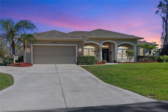 view of front of house with a garage and a lawn