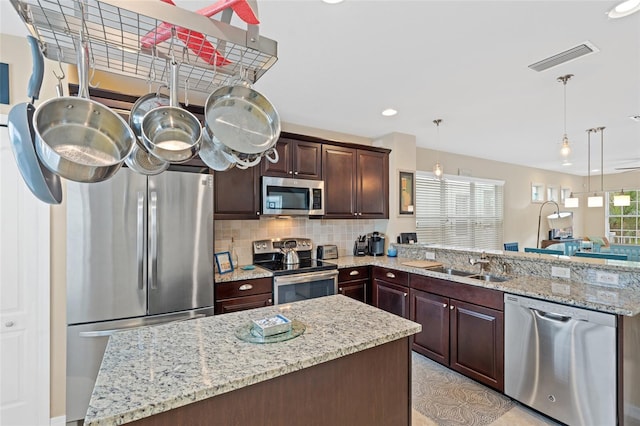 kitchen with stainless steel appliances, tasteful backsplash, visible vents, a sink, and a peninsula