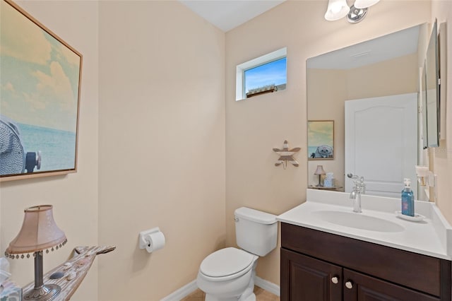 half bath featuring toilet, baseboards, and vanity