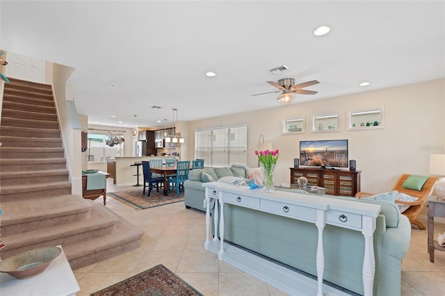 living area featuring stairway, light tile patterned flooring, visible vents, and recessed lighting