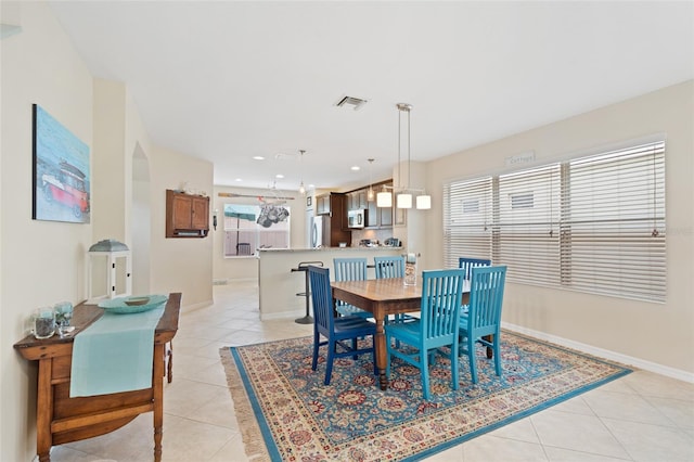 dining room featuring a wealth of natural light, visible vents, baseboards, and light tile patterned flooring