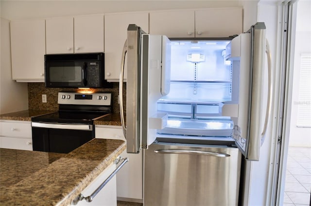 kitchen featuring electric stove, freestanding refrigerator, black microwave, and white cabinetry