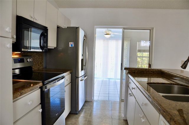 kitchen featuring dark stone counters, a sink, stainless steel appliances, white cabinetry, and backsplash