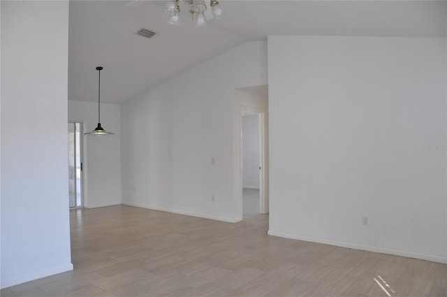 spare room featuring vaulted ceiling, baseboards, visible vents, and light wood-style floors