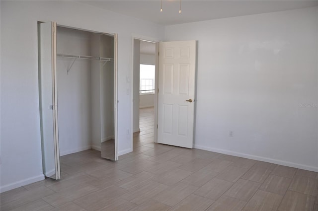 unfurnished bedroom with baseboards and a closet