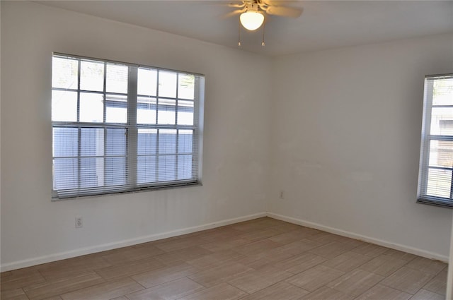 spare room with light wood-style flooring, baseboards, and a ceiling fan