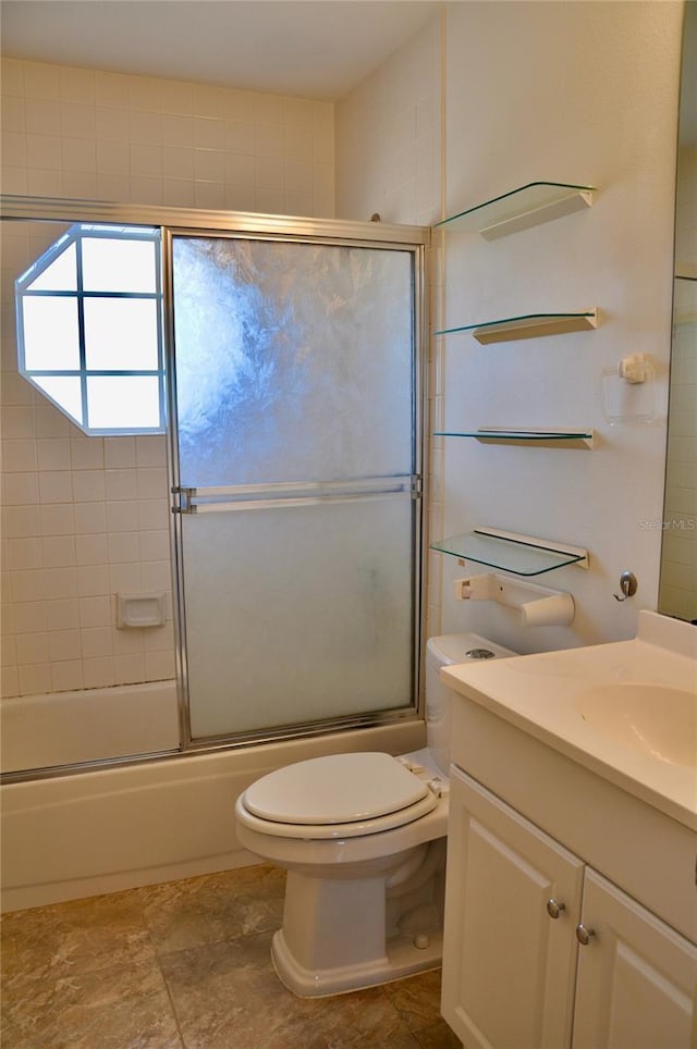 bathroom featuring toilet, enclosed tub / shower combo, and vanity