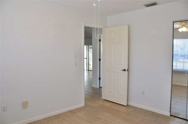 spare room with light wood-type flooring, baseboards, and visible vents