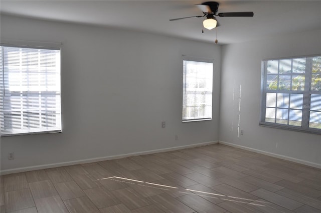 empty room with baseboards and a ceiling fan