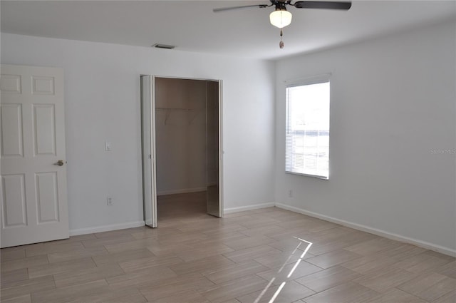 unfurnished bedroom featuring a closet, visible vents, light wood-style flooring, ceiling fan, and baseboards