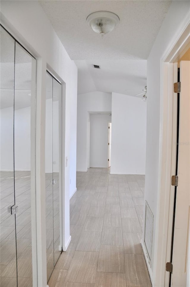 corridor with visible vents and a textured ceiling