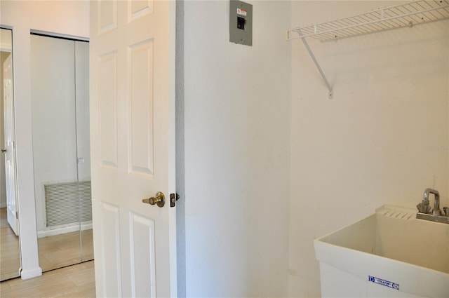 laundry area with light wood-style floors, laundry area, visible vents, and a sink