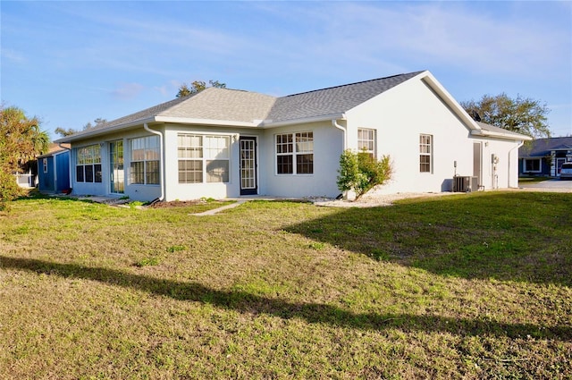 exterior space with central air condition unit, a front lawn, and stucco siding