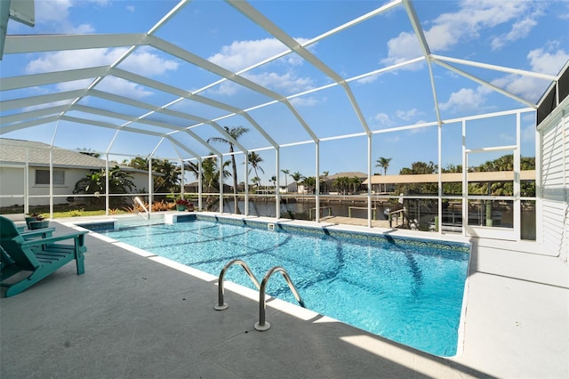 pool with glass enclosure, a water view, and a patio