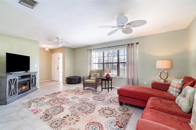 living area with visible vents, ceiling fan, baseboards, and light tile patterned floors