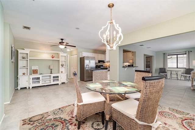 dining room featuring ceiling fan with notable chandelier, light tile patterned flooring, and visible vents