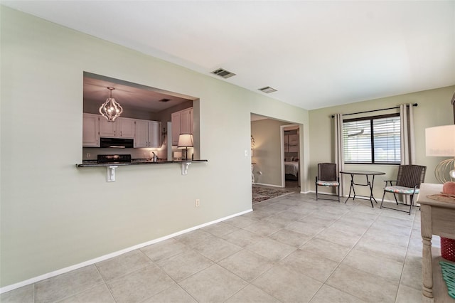 interior space with light tile patterned floors, baseboards, and visible vents